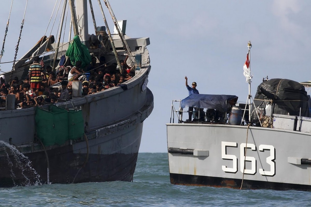 Hôm 3/6, Myanmar đã cứu 727 người di cư lênh đênh ngoài biển nhiều ngày ở ngoài khơi bang Rakhine. Những người này lên bờ vào khoảng 9h30 sáng (giờ địa phương) tại quận Maungdaw. Ảnh: Một sĩ quan quân đội Myanmar ra hiệu lệnh cho  những người di cư trên con tàu lênh đênh ngoài khơi đảo Leik trên vùng biển Andaman.